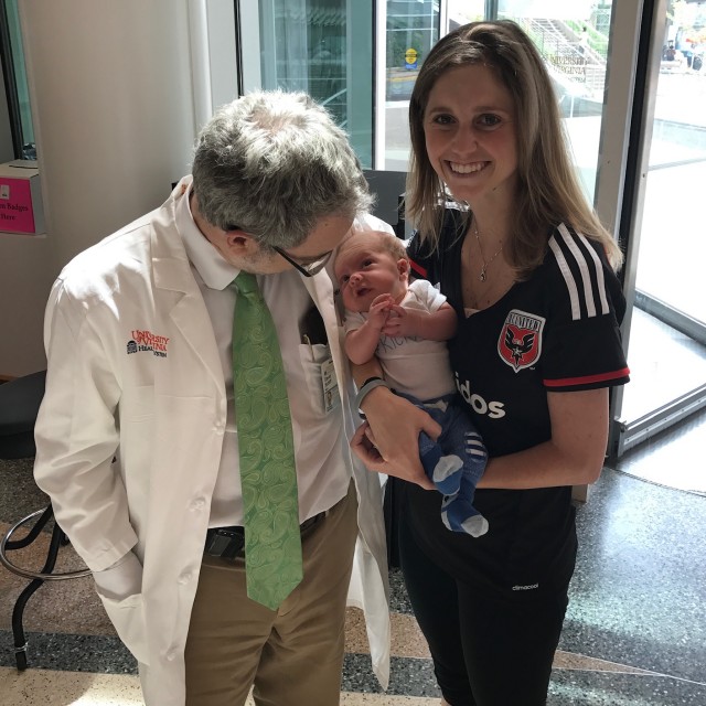 Ashleigh, Robert, and their young son at a cancer research donor display.