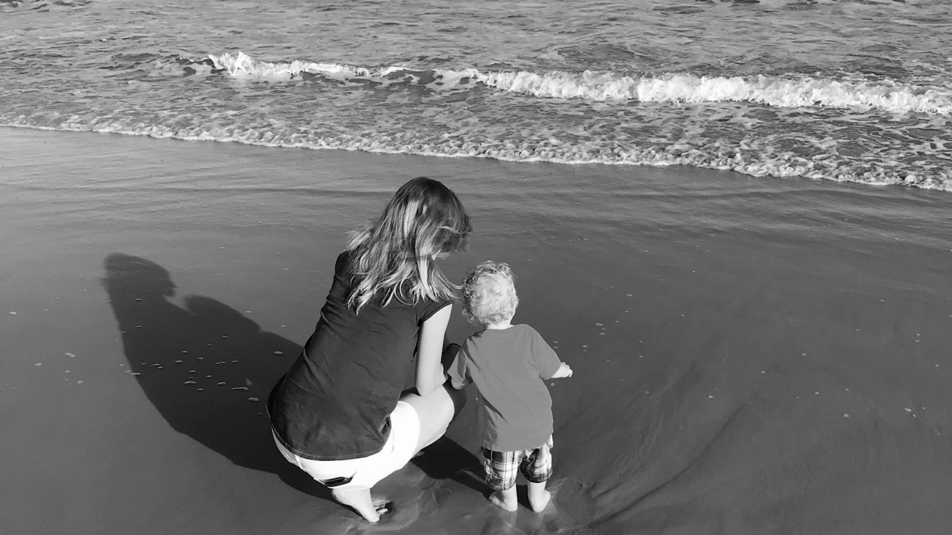 A woman and young child at the shoreline.